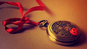 Morning Journaling Benefits Beautiful vintage locket with red ribbon and ladybug, symbolizing personal reflection and creativity.